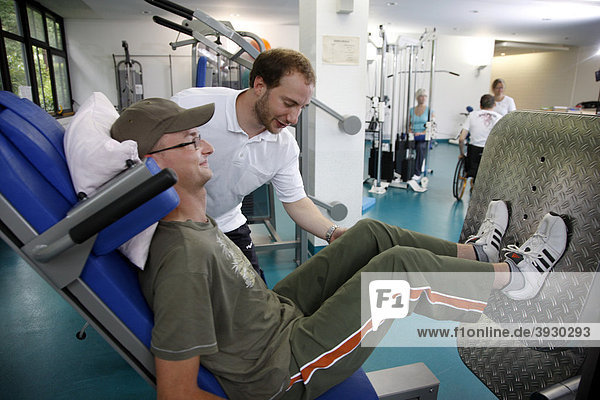 Patient beim Muskelaufbautraining an verschiedenen Kraftmaschinen im Trainingsraum  Krankengymnastik  Physiotherapie in einem neurologischen Rehabilitationszentrum  Bonn  Nordrhein-Westfalen  Deutschland  Europa