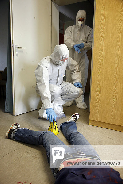Officers of the C.I.D.  the Criminal Investigation Department  gathering forensic evidence at a crime scene  after a capital offence  a homicide  re-enacted scene