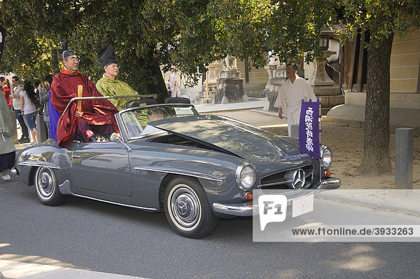 Priester fährt in der Prozession mit einem Mercedes hochgeklappte Kühlerhaube damit man den Fahrer kaum sieht Hirano Schrein Kyoto Japan Asien