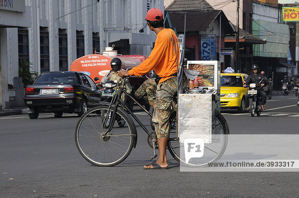 Rikschafahrer mit Garküche im Straßenverkehr  Jogyakarta  Mitteljava  Indonesien  Südostasien  Asien