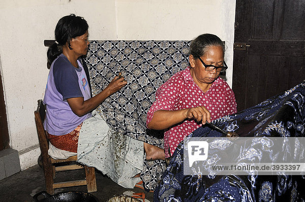 Women applying wax with a canting tool on a pattern in a batik factory  near Yogyakarta  Central Java  Indonesia  Southeast Asia