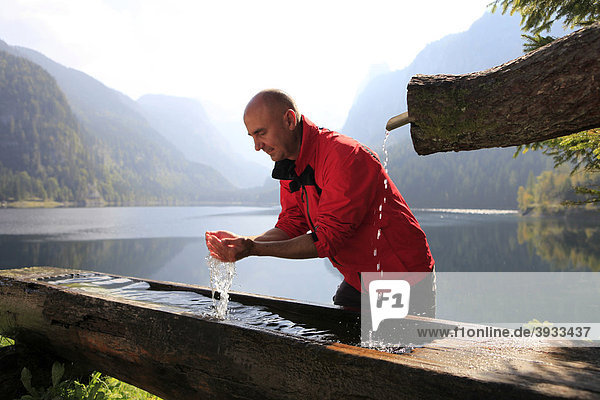 Hiker refreshing himself with water  Gosau  Lake Gosau  Salzkammergut  Upper Austria  Austria  Europe