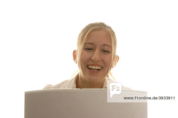 Achtzehnjährige Frau hinter Laptop  lächelnd