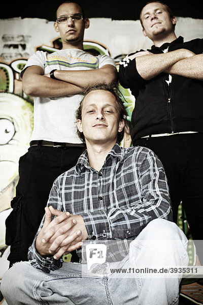 Drei Jugendliche vor einer Graffitiwand direkter Blick Jugendliche Gruppe cool