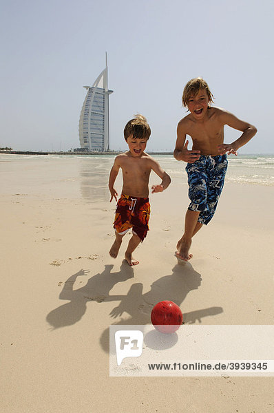 Kinder spielen Fußball am Strand vor Burj al Arab-Hotel  Dubai  Vereinigte Arabische Emirate  Naher Osten