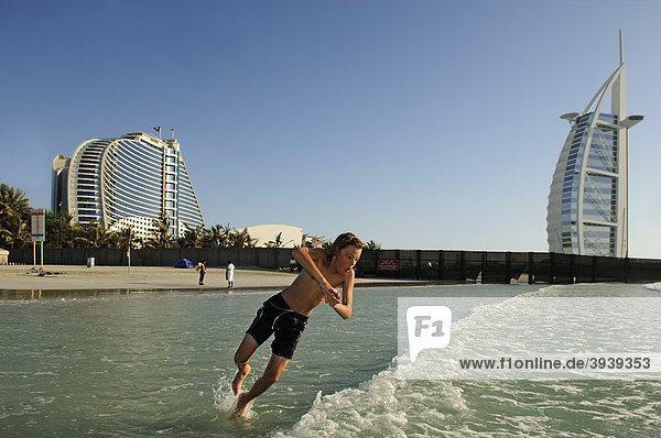 Junge springt in Wellen vor Burj al Arab-Hotel  Dubai  Vereinigte Arabische Emirate  Naher Osten