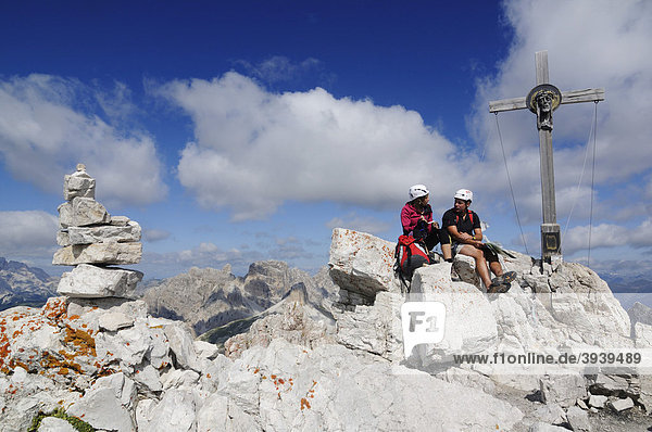 Kletterer am Gipfelkreuz bei Klettersteig-Tour auf den Paternkofel  Hochpustertal  Sextener Dolomiten  Südtirol  Italien  Europa