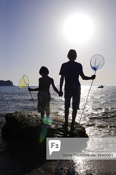 Children fishing with dip nets  Cala Conta  Ibiza  Pine Islands  Balearic Islands  Spain  Europe