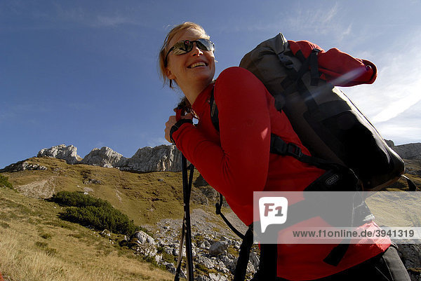 Hiker  young woman with a backpack and trekking poles takes a break during the ascent to Mt. Heidachstellwand  2192m  Rofan  Achensee  Tyrol  Austria  Europe
