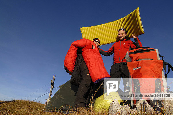 Hikers  young man and woman having fun while putting up a bivouac with tent  sleeping bag  backpack and sleeping pad  Heidachstellwand  Rofan  Achensee  Tyrol  Austria  Europe