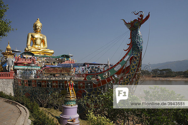 Goldene Statue des Buddha und stilisiertes Boot aus Stahl am Mekong  Goldenes Dreieck zwischen Thailand  Myanmar und Laos  Sop Ruak  Nordthailand  Thailand  Asien