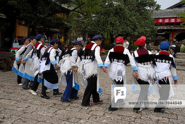Tanz der Marktfrauen  Ethnologie  Frauen der Naxi Ethnie in Tracht tanzen auf dem alten Marktplatz  Nakhi  Altstadt  Lijiang  UNESCO Weltkulturerbe  Provinz Yunnan  Volksrepublik China  Asien