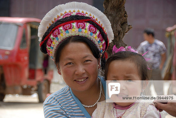 Portrait  Ethnologie  Frau der Bai Ethnie mit typischem Kopfschmuck und Kleinkind  Yongning  Lugu Hu See Gebiet  Provinz Yunnan  Volksrepublik China  Asien