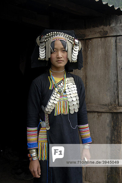 Portrait  Ethnologie  junge Frau der Akha Pixor Ethnie gekleidet in Tracht  Haube als Kopfschmuck  viele Silbermünzen als Schmuck  Dorf Ban Moxoxang  Distrikt Phongsali  Provinz Phongsali  Phongsaly  Laos  Südostasien  Asien