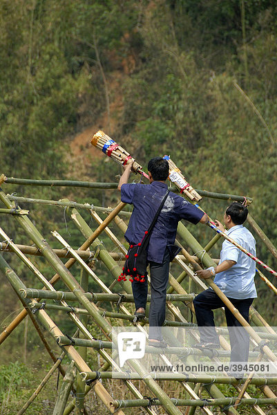 Männer legen Raketen auf Abschussrampe  Pi Mai  Laotisches Neujahrsfest  Volksfest  Phongsali Stadt  Phongsali Provinz  Phongsaly  Laos  Südostasien  Asien