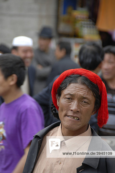 Portrait  Tibeter mit rotem Haarband  Altstadt von Lhasa  Himalaya  Autonomes Gebiet Tibet  Volksrepublik China  Asien