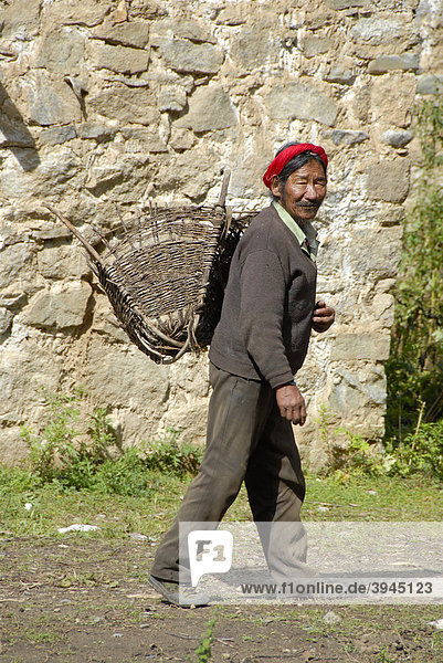 Tibetan man carrying a basket on his back  pannier  Nyango village near Samye  Himalayas  Tibet Autonomous Region  People's Republic of China  Asia
