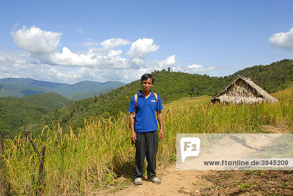 Laotian man on path in front of rice field with cabin in a mountain landscape  near Ban Saenyang  Muang Khoua district  Phongsali province  Laos  Southeast Asia  Asia