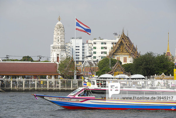 Boot auf dem Mae Nam Chao Phraya River Fluss  thailändische Nationalflagge  dahinter buddhistischer Tempel  Bangkok  Thailand  Südostasien  Asien