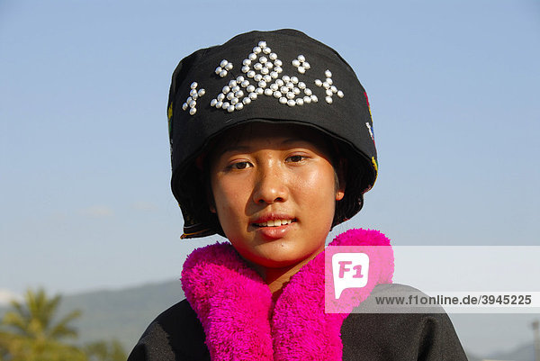 Portrait  junge Frau der Yao Ethnie  Mien  in Tracht  traditionelle Kleidung  Kopfbedeckung  rosa-farbener wolliger Schal  Vang Vieng  Laos  Südostasien  Asien