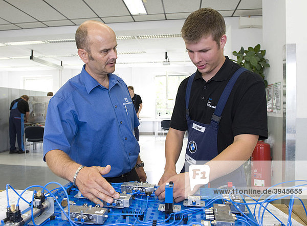 Im BMW-Ausbildungszentrum für Kfz-Mechatroniker erklärt Meister Andreas Fischer einem Auszubildenden eine elektrische Schaltung  München  Bayern  Deutschland  Europa