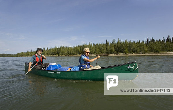 Älteres Paar  Mann und Frau paddeln in einem Kanu  oberen Liard River  Yukon Territory  Kanada