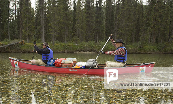 Zwei Männer paddeln in einem Kanu  Kanufahren  im klaren  flachen Wasser des oberen Liard River  Yukon Territory  Kanada