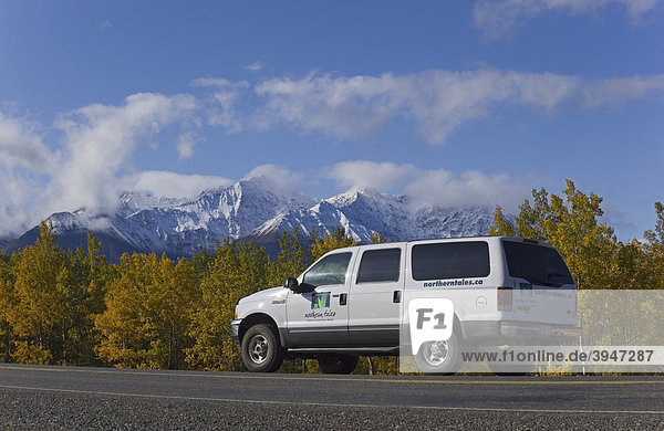 Geländewagen fährt Alaska Highway entlang  Indian Summer  Blätter in Herbstfarben  St. Elias Mountains dahinter  Kluane Nationalpark und Reservat  Yukon Territory  Kanada