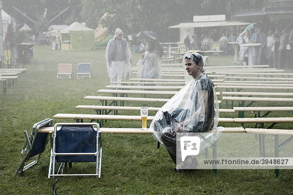 Frau sitzt im Regen während eines Konzerts im Bürgerpark Pankow  Berlin  Deutschland  Europa