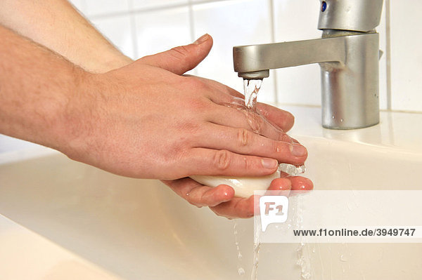 Person wäscht sich die Hände mit Seife