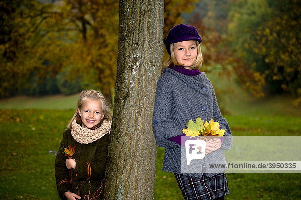 Two sisters in a park in autumn
