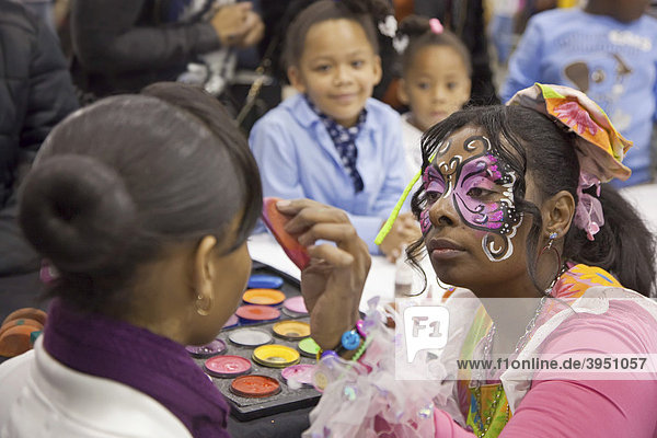 Face painting at the annual Adopt-a-Child Christmas Party for children from low-income families  Detroit  Michigan  USA