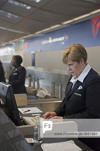 A worker at the Northwest Airlines  Delta ticket counter at Detroit Metropolitan Airport  Romulus  Michigan  USA