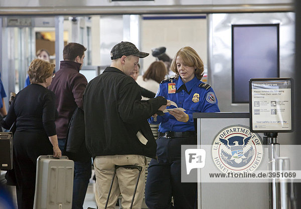 An officer of the Transportation Security Administration checks identification of passengers at Detroit Metropolitan Airport  Romulus  Michigan  USA