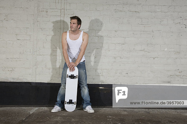 Skateboarder standing in front of a wall