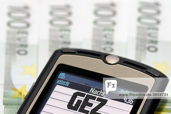 Handy mit GEZ-Logo auf Geldscheinen  Symbolfoto GEZ-Gebühren für Handys