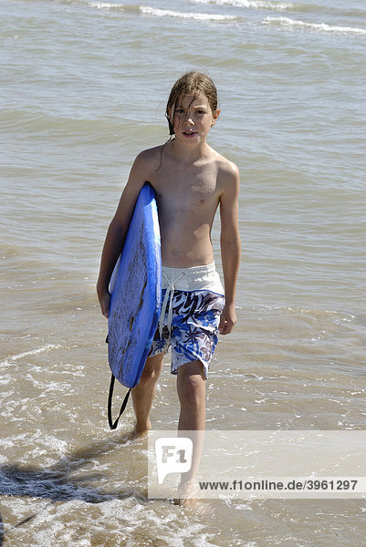 Kind mit Surfboard  Boogyboard  am Strand am Meer