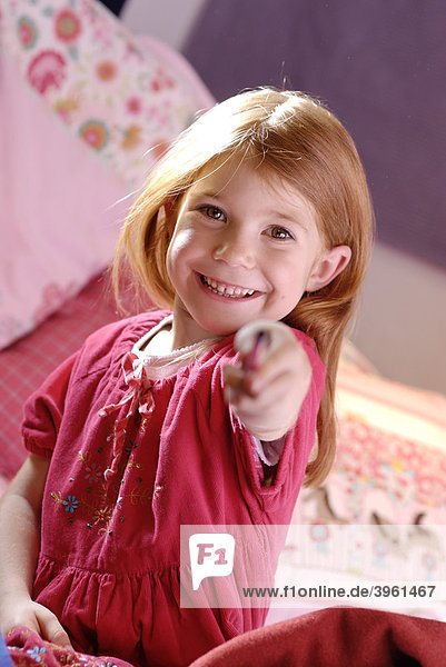Little girl holding a pen in her hand