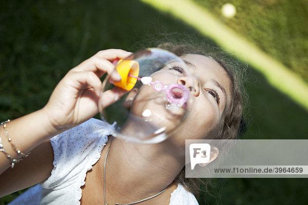 Kleines Mädchen macht Seifenblasen