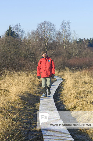 Hohes Venn Naturschutzgebiet im Winter  Wanderer auf einem gefrorenen Holzweg  Eupen  Provinz Lüttich  Belgien