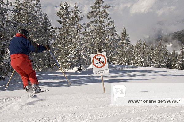 Reckless skier ignoring prohibition sign  illicitly skiing into the forest