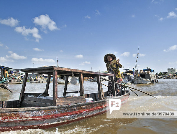 Frau mit traditionellem Hut  Kegelhut aus Palmenblättern  rudert stehend ein Holzboot am Mekong  Mekongdelta  Vietnam  Asien