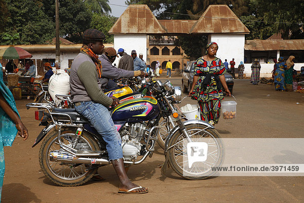 Man with motorcycle on the market  Sultan's Palace  Foumban  Cameroon  Africa