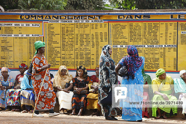 Frauen vor dem Sultanspalast  warten auf Audienz beim Sultan  dahinter Tafeln zur Geschichte der Bamundynastie  Foumban  Kamerun  Afrika