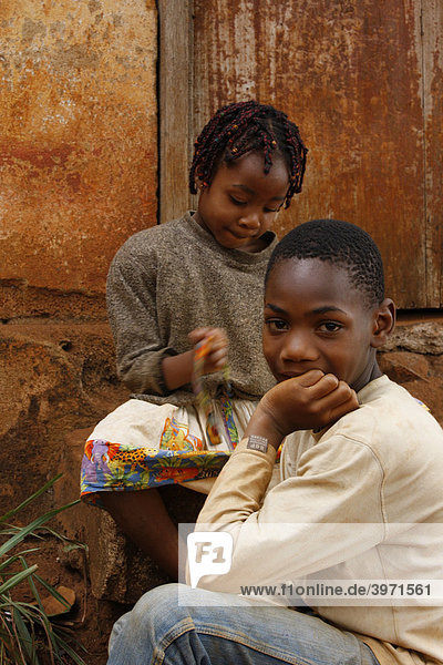 Boy and girl in front of a door  Bafoussam  Cameroon  Africa