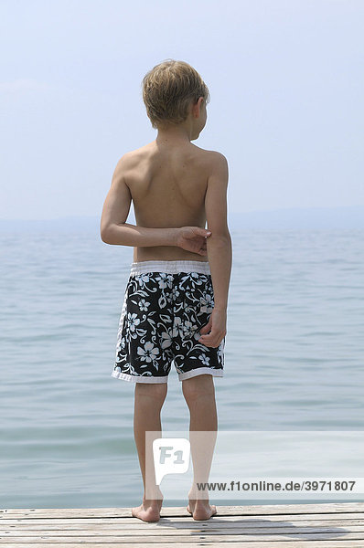 6jähriger Junge steht am Ufer und schaut auf den Gardasee  Italien  Europa