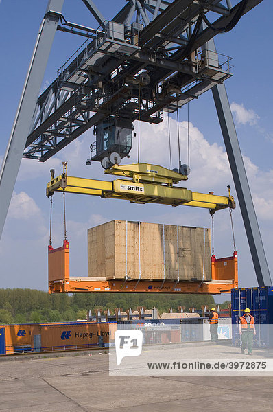 Containerterminal Bonn  Portalkran hebt Spezialladung auf Containerflat vom Kai aufs Binnenschiff  Arbeiter überwachen Ladevorgang  Nordrhein-Westfalen  Deutschland  Europa