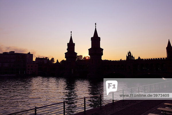 Silhouette of the Oberbaumbruecke bridge across the Spree river at sunset in Berlin Germany Europe