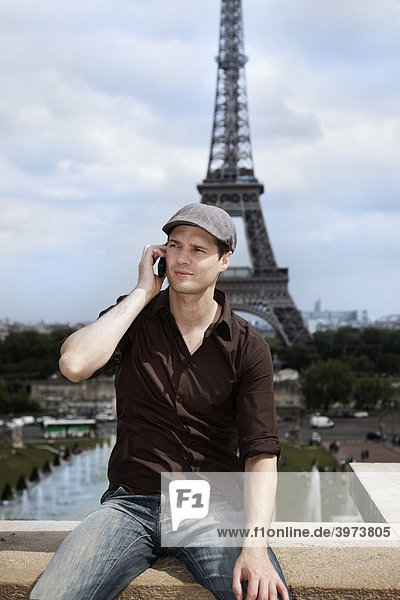 Junger Mann vor dem Eiffelturm  Paris  Frankreich  Europa