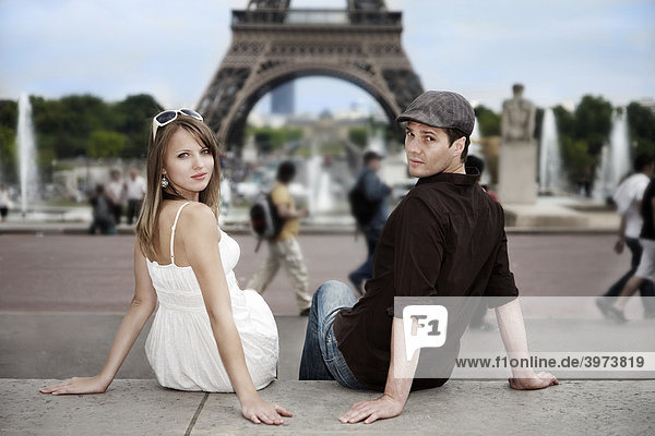 Junges Paar sitzt vor dem Eiffelturm  direkter Blick  Paris  Frankreich  Europa